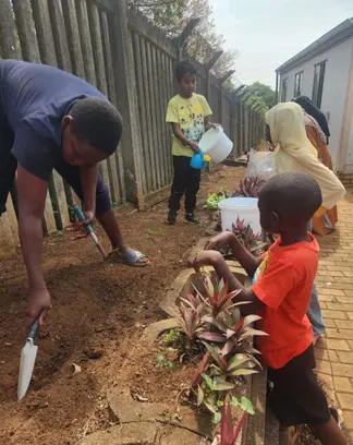 Learners working in the school garden with a teacher