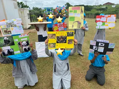 Learners holding up their animal project posters